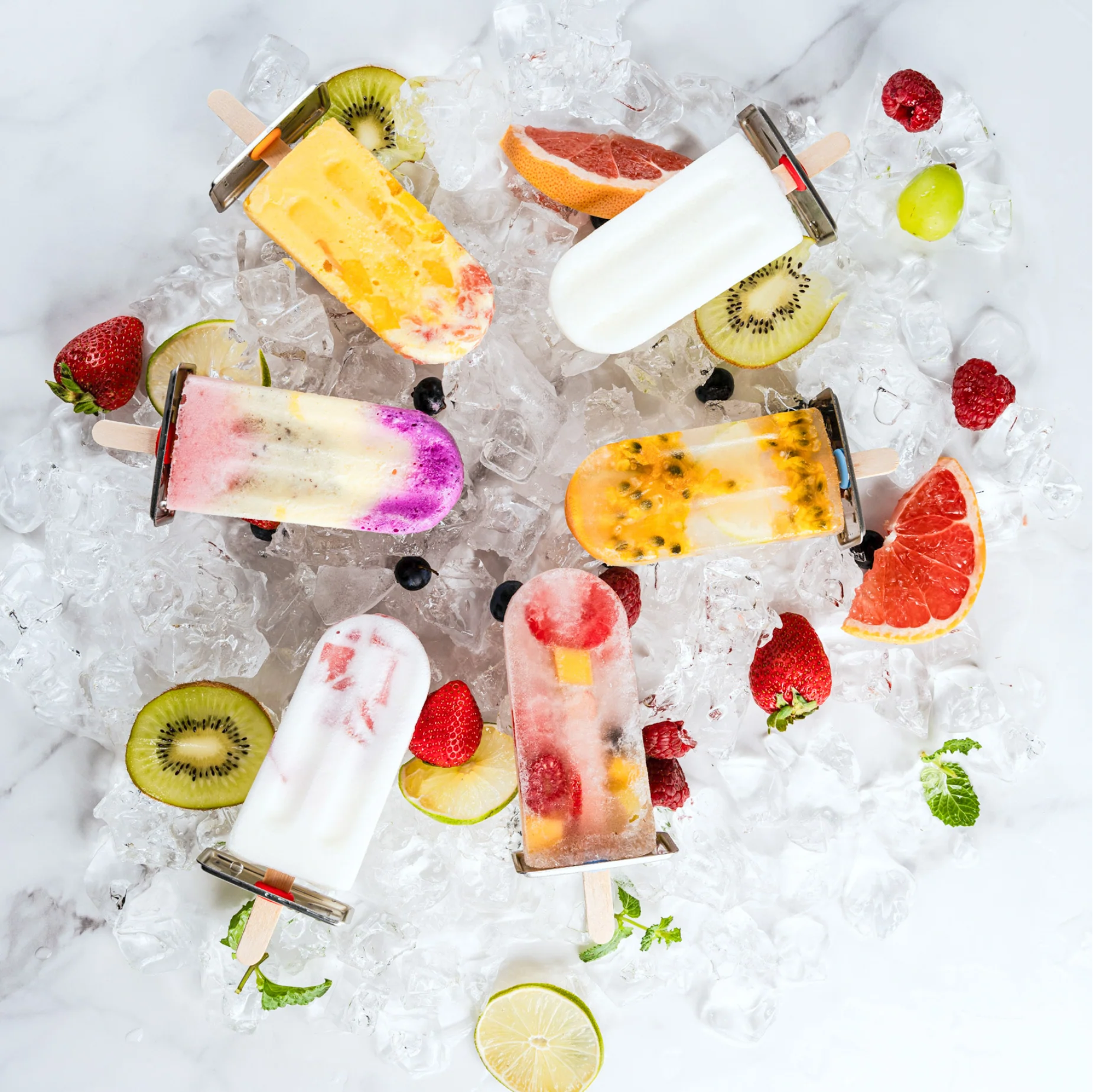 Eis am stiel formen in Aktion mit frischen Früchten wie Kiwi und Limetten auf einem Eiswürfelberg.